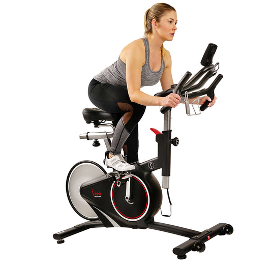 Woman exercising on Sunny Health & Fitness stationary bike with magnetic resistance and enhanced Bluetooth connectivity